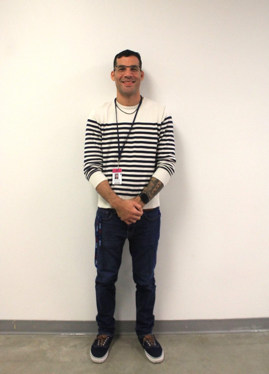 Raul Rivera pauses to smile as he diligently walks the hallways to help students in need.