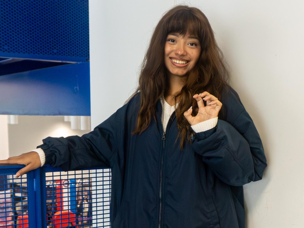 Mariana Lopez Trujillo grins widely as she represents Melbourne's Mascot with the bear claw sign.